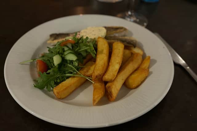 Delicately cooked sea bass served with chips and salad at Formby Hall's Fairway Grill restaurant.