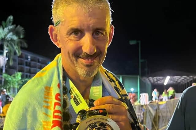 Triathlete Barnaby Grey proudly displays his Kona Ironman finishers medal.