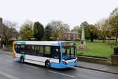 Stagecoach bus drives past a war memorial