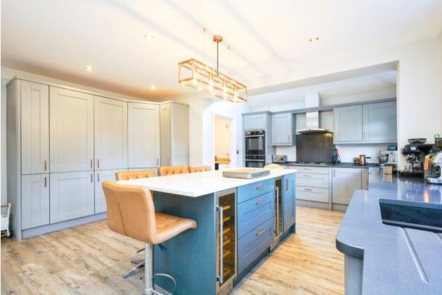 The kitchen is linked by internal bi-folding doors. It is a modern fitted kitchen with central island with breakfast bar and two wine fridges.