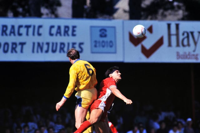 Peter Haddock rises high to clear the ball under pressure from Bournemouth's Kevin Bond.
