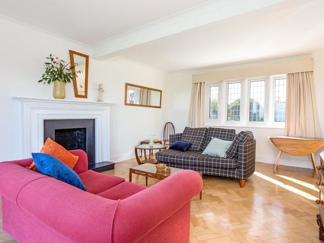Parquet flooring and a feature fireplace within this sunny room.