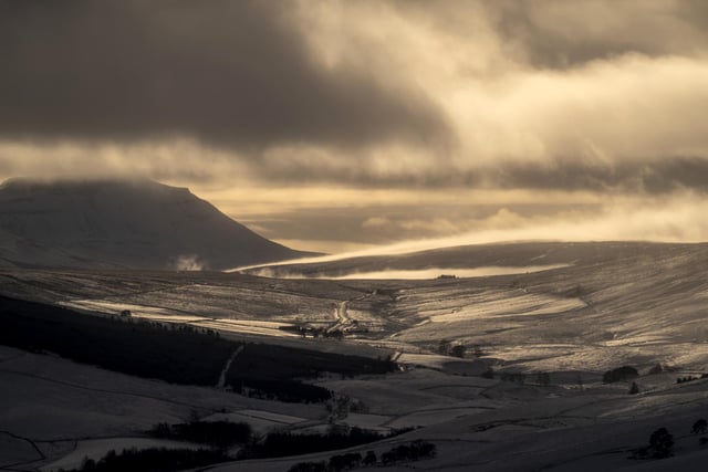Sunlight is reflected off snow covered hills in the Yorkshire Dales National Park.