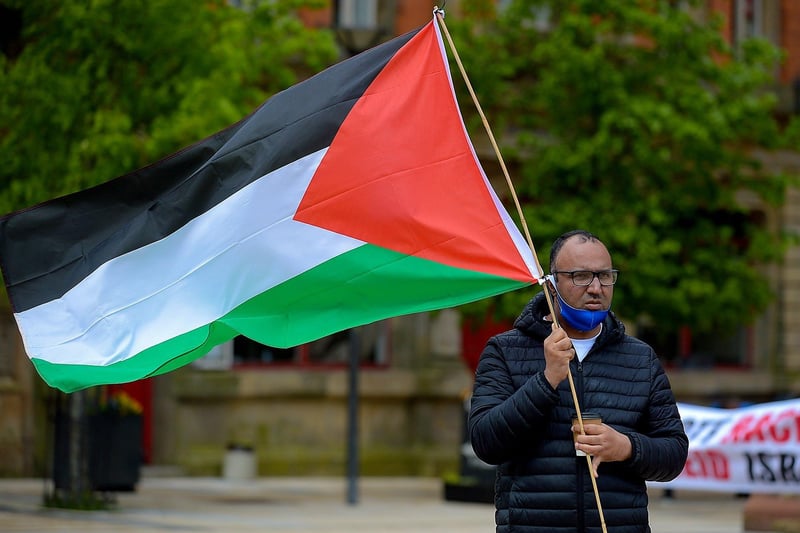 Sameh, from Egypt, waves a Palestinian flag during Saturday afternoon‘s rally, at Guildhall Square, in solidarity with the people of Palestine. Photo: George Sweeney.  DER2119GS – 020