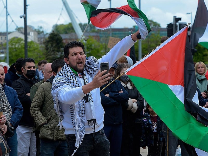 Protester with Israeli flags tied to his shoes during the rally in Guildhall Square, on Saturday afternoon last, calling for an end to the violence against the people of Palestine. Photo: George Sweeney.  DER2119GS – 036