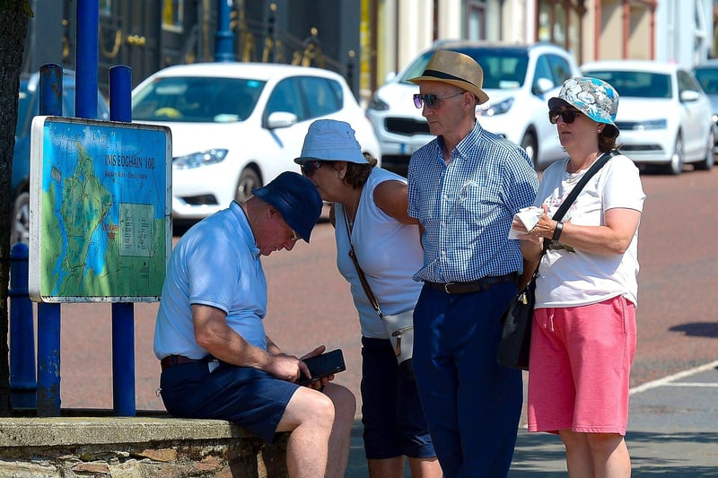 Visitors consult a map of Inishowen, in Moville, during the recent mini heat wave in Inishowen. DER2129GS - 070