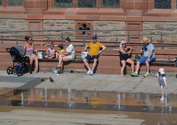 People relax in in the sun in Guildhall Square during the recent mini heatwave. DER2129GS - 064