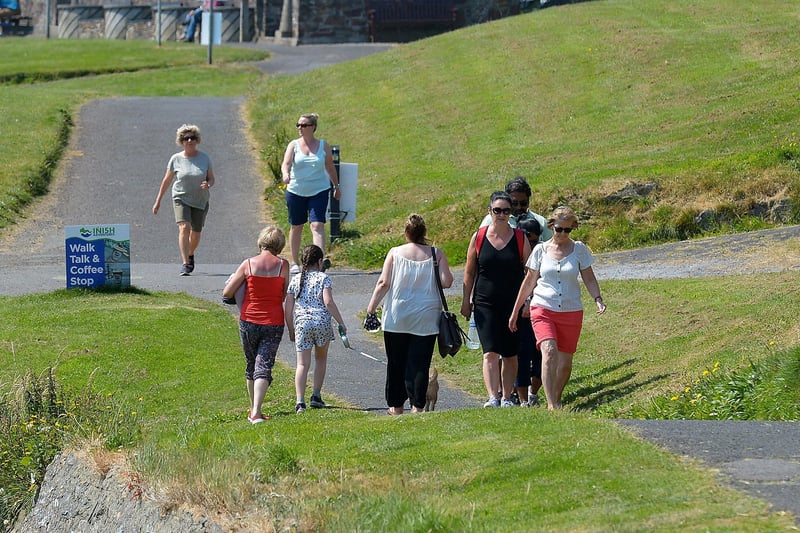 People enjoy a walk along the the shore front in Moville during the recent hot spell in Inishowen. DER2129GS - 068