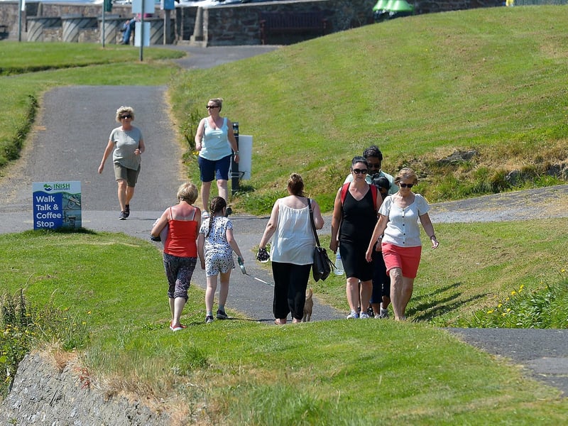 People enjoy a walk along the the shore front in Moville during the recent hot spell in Inishowen. DER2129GS - 068
