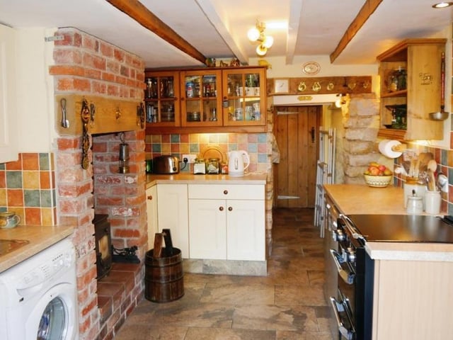A third shot of the kitchen, which is both cute and rustic. It is fitted with a matching range of base and eye-level units, plus worktops and a stainless steel sink with single drainer and mixer tap. There is plumbing for an automatic washing machine and an electric point for a cooker.