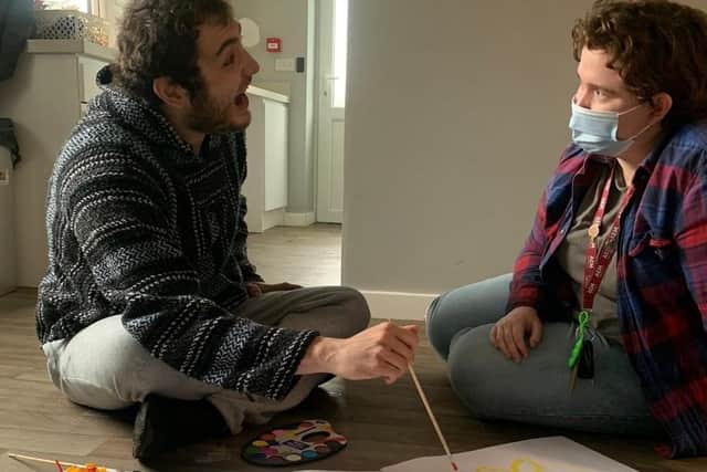 An East Midlands Autism support worker with a person enjoying artwork activities.
