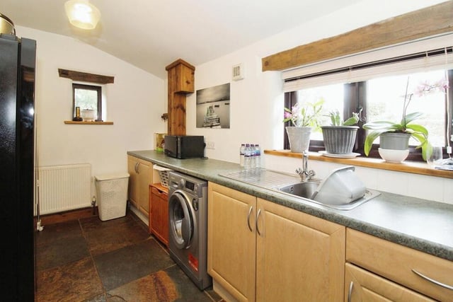 Close to the breakfast kitchen is this useful utility room, with space for a washing machine. It includes a fitted worktop with base units beneath, a stainless steel sink unit and a slate floor.