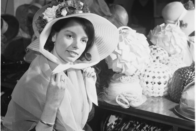 Sally Hunter tries on Easter bonnets in Edinburgh's Edward French's millinery salon in April 1960.