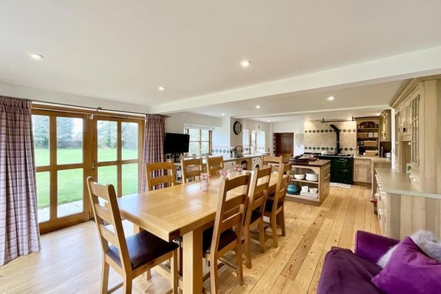 Within the open-plan area, there is space for a dining table, in front of French doors that open on to the property's grounds at the back.