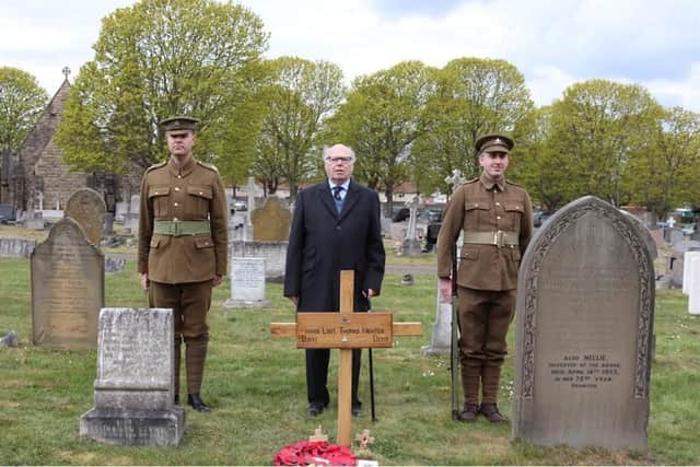 Robert Ilett standing behind the grave with the cross installed, flanked by the two men in authentic Notts and Derby Regiment uniforms of 1918.