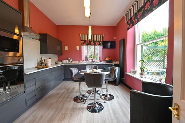 There are fully fitted kitchens on both floors of the Worksop house. This colourful, contemporary one contains an electric hob, built-in fridge and freezer, fitted washing machine, dishwasher, fitted electric oven with built-in microwave, and full marble tops all round,.