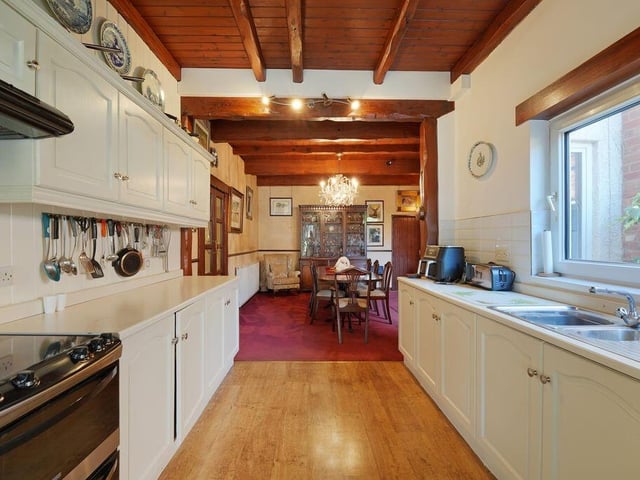 The fitted kitchen leads through to a beamed dining room.
