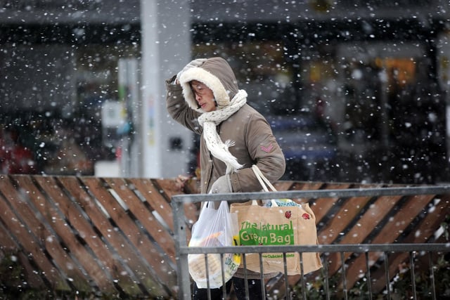 A woman crosses the road in Baillieston in the snow and icy and windy conditions in Feb 2010.