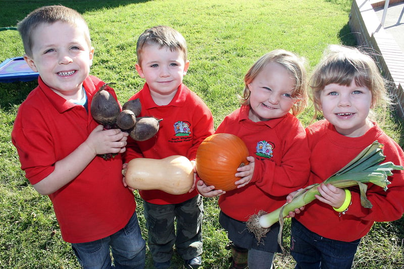 Harry Brown, Aiden Gwyther, Katie Gillott and Niamh Brentnall bring produce to South Wingfield pre-school playgroup's harvest festival in 2009.