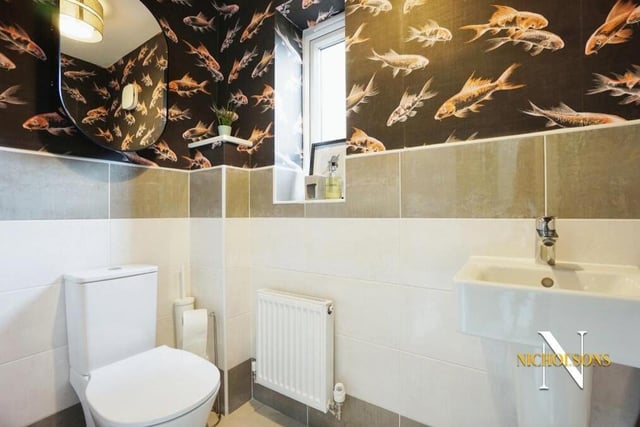 Just off the open-plan kitchen is a handy utility room and also this wonderfully decorated downstairs toilet, featuring a low-flush WC and hand wash basin.