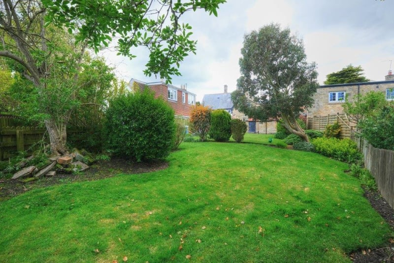 To the rear is a good sized lawn garden with mature flowerbeds.