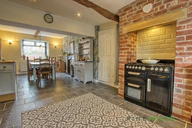 A focal point of the kitchen is a terrific range-style cooker in an inglenook. There's also an integrated dishwasher and fridge, while the whole space is open plan and flows seamlessly into a dining area.
