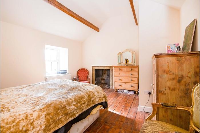 With a vaulted ceiling with exposed beams, a wooden floor and a double-glazed, sash window to the front elevation providing views over the village. A door opens to the ensuite and there is a central heating radiator.