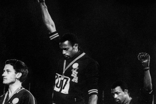 During their medal ceremony, African-American athletes Tommie Smith and John Carlos each raised a black-gloved fist during the playing of the US national anthem to protest. They then turned to face the US flag and kept their hands raised until the anthem had finished.