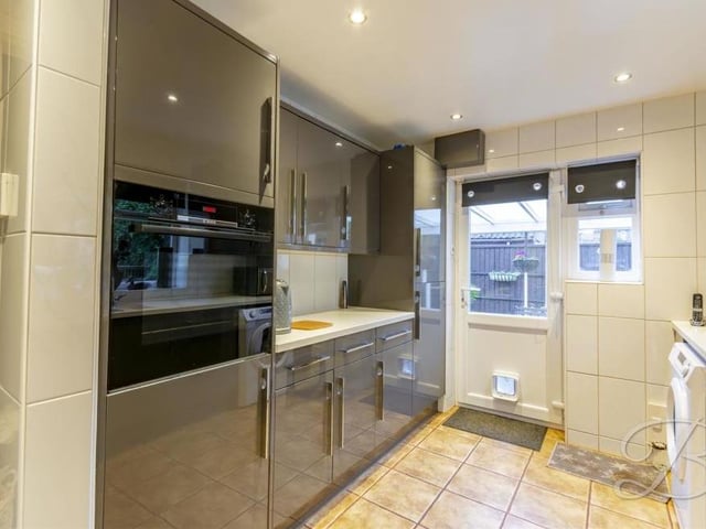 Deeper into the bungalow sits this kitchen, which comes complete with an attractive, modern range of grey gloss units and cabinets. Not forgetting complementary worktops, an inset sink and drainer, downlights, central heating radiator and windows to the side and rear of the property.
