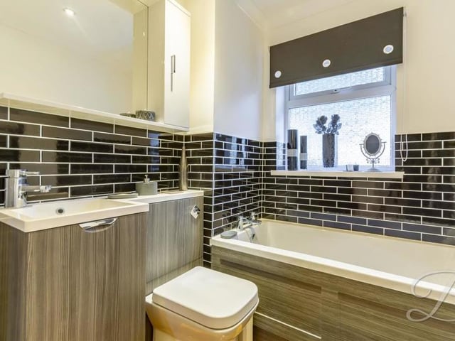 Our inspection of the £350,000 bungalow's interior is completed by a peek at the gorgeous family bathroom, complete with modern fixtures and fittings. It comprises a panelled bath, low-flush WC and wash basin with storage.