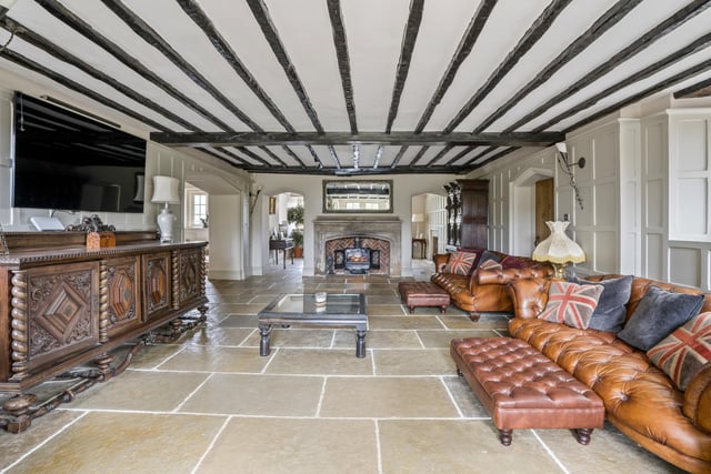 How about this for a superb sitting room on the ground floor? Ceiling beams, a stone fireplace and flagstone flooring are just some of its compelling features.