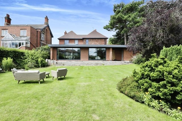 Glorious gardens can be found at the front and back of the £900,000 house. This is the view from the rear, where a lovely lawn is bordered by mature shrubs. There is also space for a large patio.