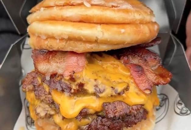 he gut-busting meal contains three beef patties, six slices of cheese and two rashers of bacon - all smothered in melted butter or Biscoff spread. It is wrapped in eight sugar-covered doughnuts and contains 3,180 calories - the same as six Big Macs or over three roast dinners.