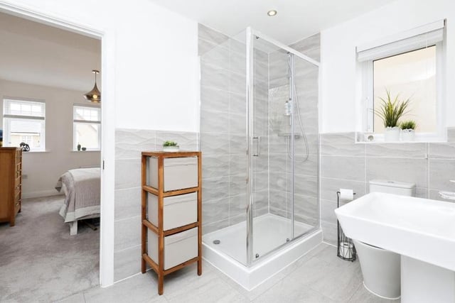The en suite to bedrooms two and three includes a double shower, wash hand basin, WC, tiled flooring and part-tiled walls.