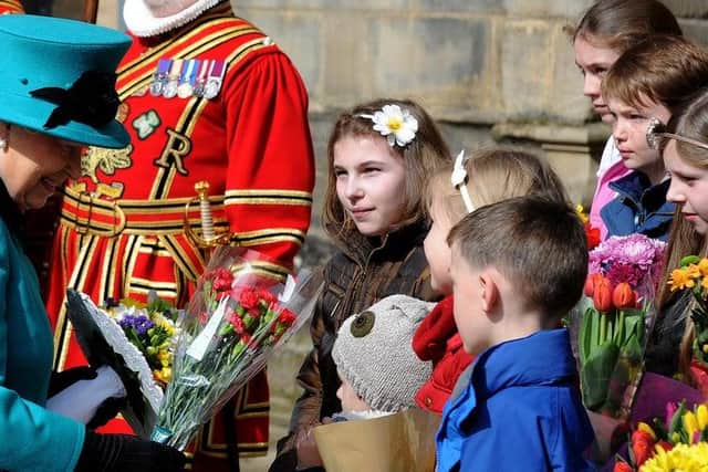 The Queen collects flowers from children outside Sheffield Cathedral for Maundy Thursday during a 2015 visit. Picture: Andrew Roe