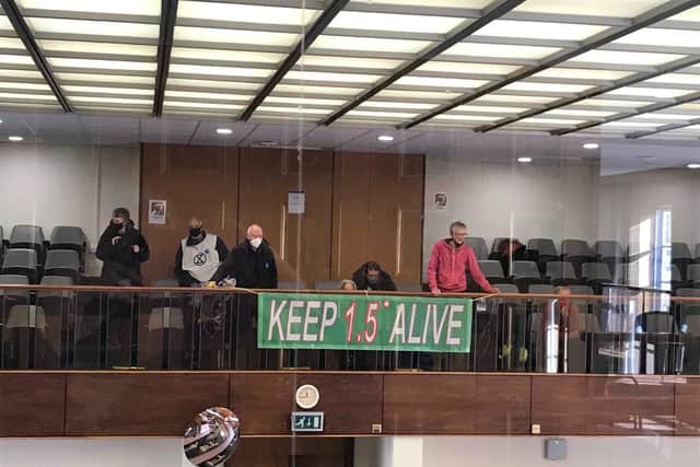 The meeting was adjourned after protestors hung a banner inside the room.