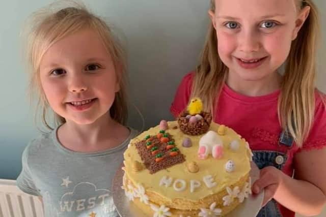 Alice and Emily Johnson, aged 5 and 8, with their Easter Hope Cake - a lemon cake with lemon buttercream.
