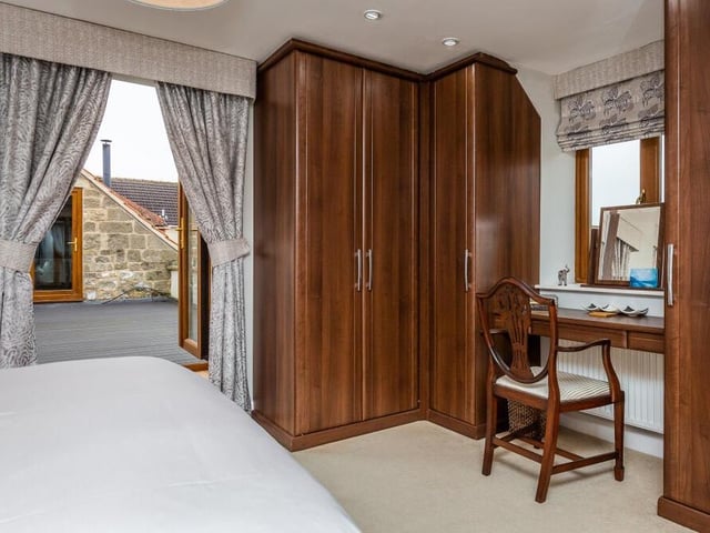 The master bedroom features fitted wardrobes and also French doors that open out on to the property's roof terrace.