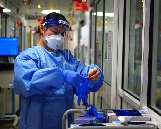 A nurse puts on personal protective equipment in a ward for Covid patients. A total of 181,434 coronavirus-related deaths were recorded throughout England by January 26.