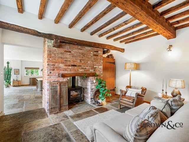 A beamed snug shares a double sided wood burner with the kitchen areas.