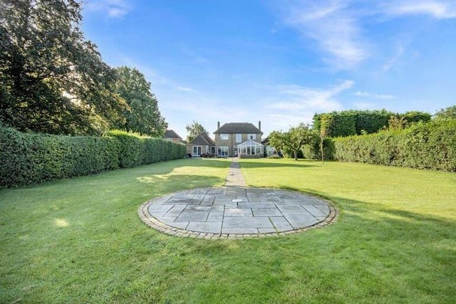 This photo shows the extent of the large lawn at the back, with a feature footpath running down the middle. The well-kept gardens at the £850,000 house exceed half an acre..