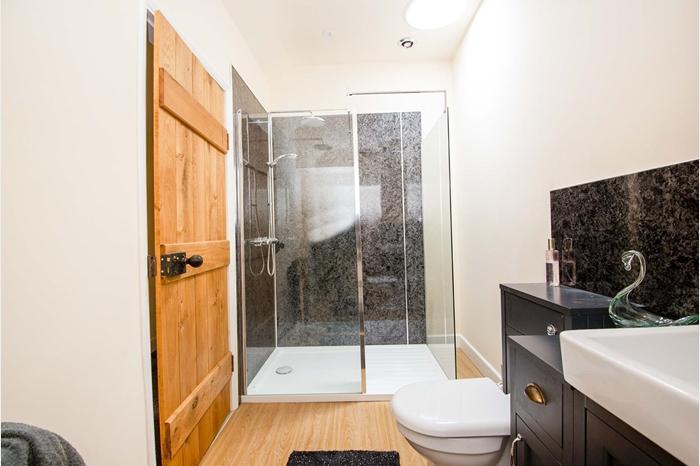 Comprising of a walk-in shower, low flush WC, wash hand basin with storage under and a chrome heated towel rail. The shower room has an extractor fan and spotlights to the ceiling.