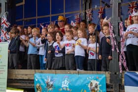 Edwinstowe pupils sing for the coronation picnic crowds, wearing Royal crowns for the historic occasion.
