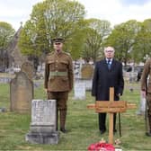 Robert Ilett standing behind Thomas Highton's grave with the temporary cross installed, flanked by the two men in authentic Notts and Derby Regiment uniforms of 1918.