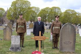 Robert Ilett standing behind Thomas Highton's grave with the temporary cross installed, flanked by the two men in authentic Notts and Derby Regiment uniforms of 1918.