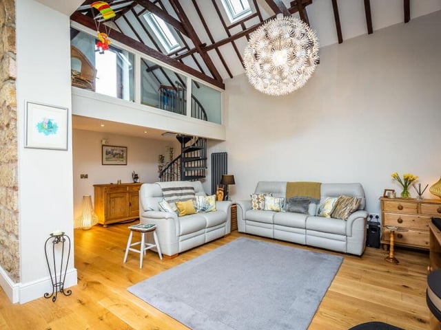 From the family room, a spiral staircase leads to a mezzanine area with glass balustrading.