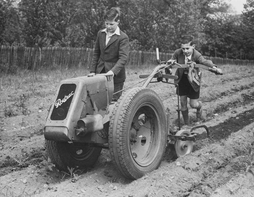 Evacuee schoolboys from London at work using a motorised Rowtrac harrowing machine on the grounds of the Ashley House School for the Dig for Victory campaign on 11th August 1941 in Worksop.