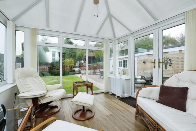 The conservatory commands size and presence. Large windows give views of the garden, while side-facing, double-glazed French doors lead outside. Other features include laminate flooring, wall lights and a ceiling fan.