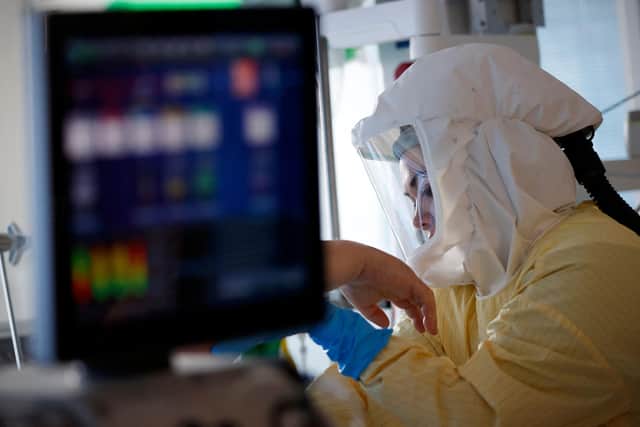 A critical care nurse in an intensive care unit. (Photo by ADRIAN DENNIS/AFP via Getty Images)
