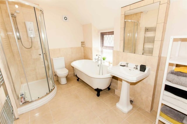 A freestanding claw foot bath wth central mixer tap and shower attachment and corner cubicle housing a shower are contained within the stunning bathroom.